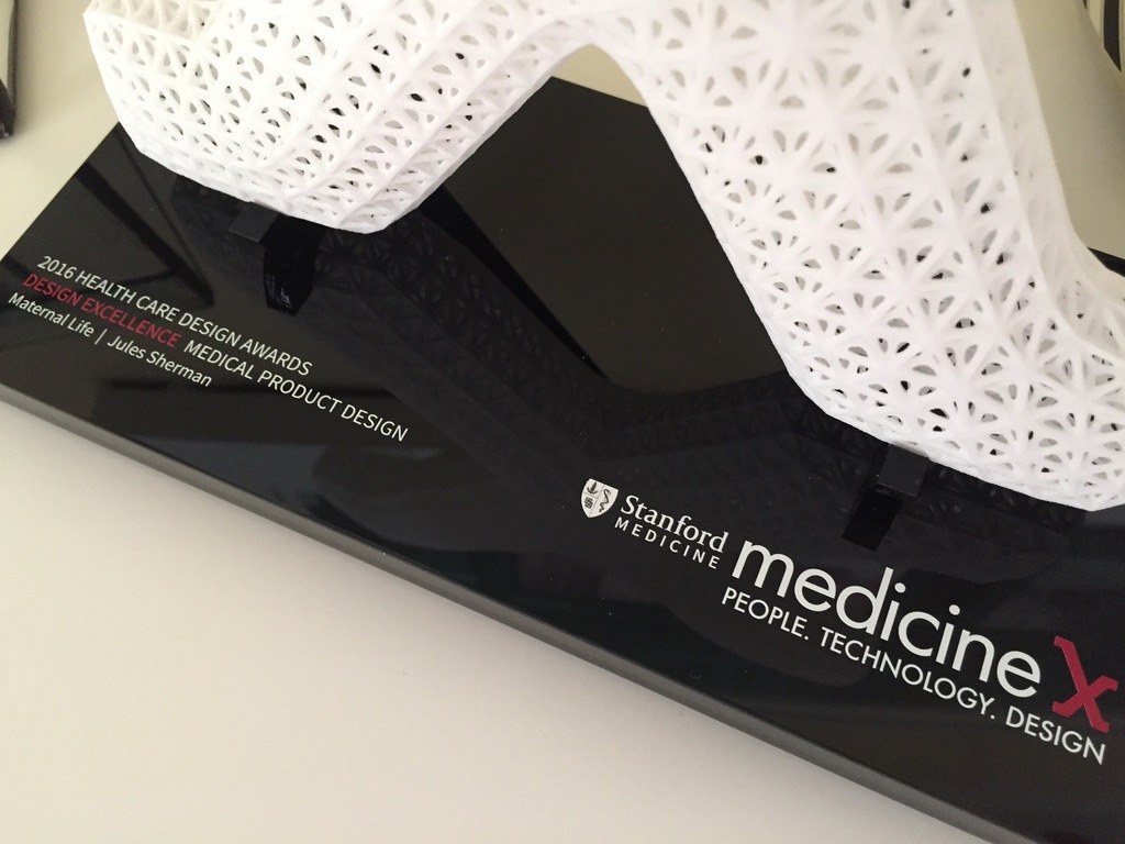 The award base, printed 2016 Health Care Design Awards, Design Excellence, Medical Product Design, Maternal Life, Jules Sherman, under a white lattice sculpture.