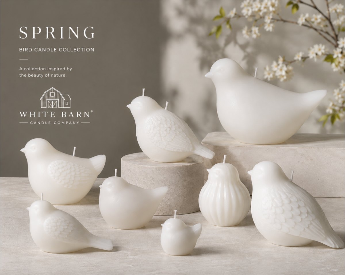 A White Barn Candle Company spring collection page: white bird shaped candles in several sizes on stone pedestals beside a flowering branch.