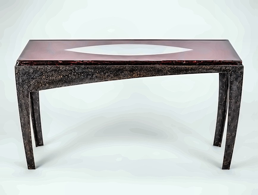 A console table with a deep red top cut with a pointed oval opening, standing on four dark tapered legs.